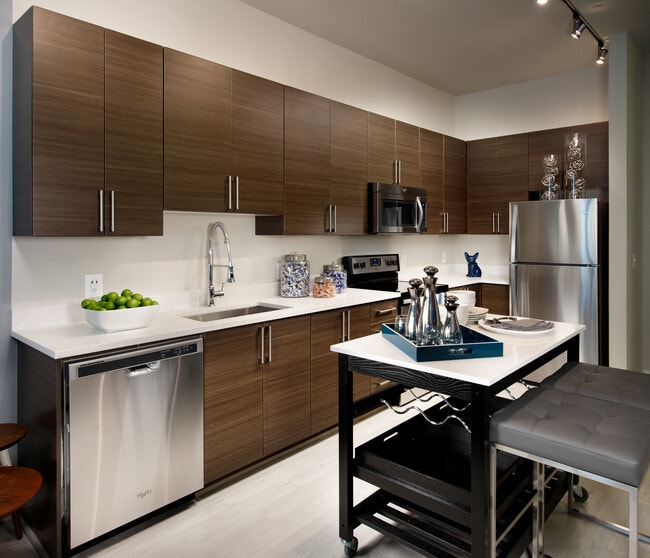 Open concept kitchen with granite countertops, European-style cabinetry, stainless-steel appliances and movable kitchen island - Avalon Dunn Loring Apartments