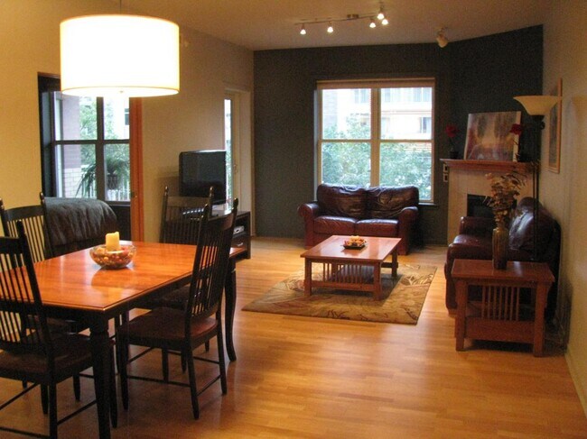 large open great room with gas fireplace, door to patio and dining area - 360 W Washington Ave Unit 305