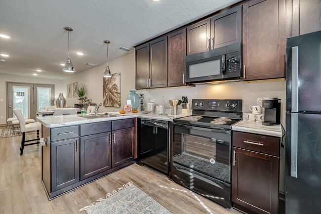 Kitchen with cherry wood cabinets and black appliances
