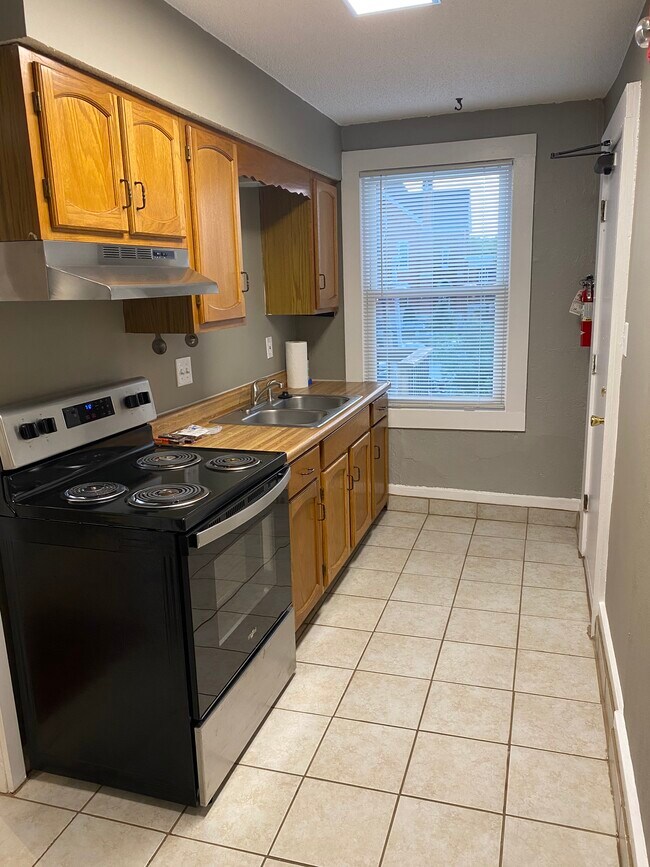 Kitchen with new range and hood - 919 Massachusetts St Unit D