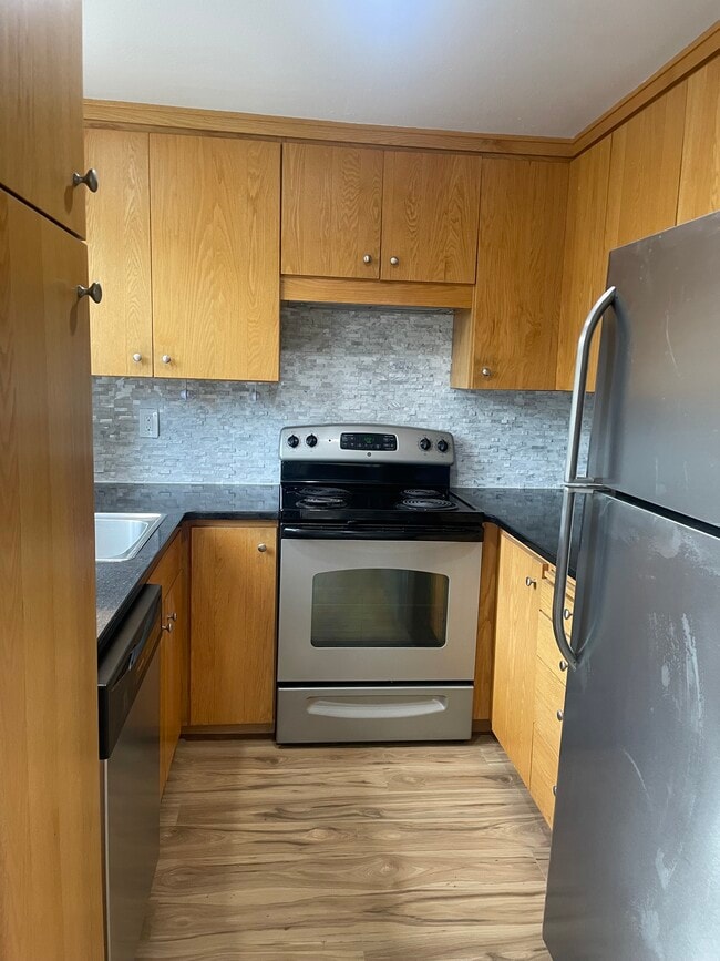 Stainless steel appliances and carrera marble backsplash in kitchen. - 1717 150th Ave SE