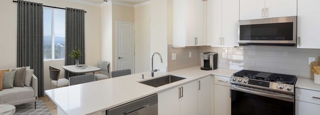 Paquete renovado I cocina y área de comedor con gabinetes blancos, encimeras de cuarzo blancas, electrodomésticos de acero inoxidable, y pisos de superficie dura - Avalon Simi Valley Apartamentos