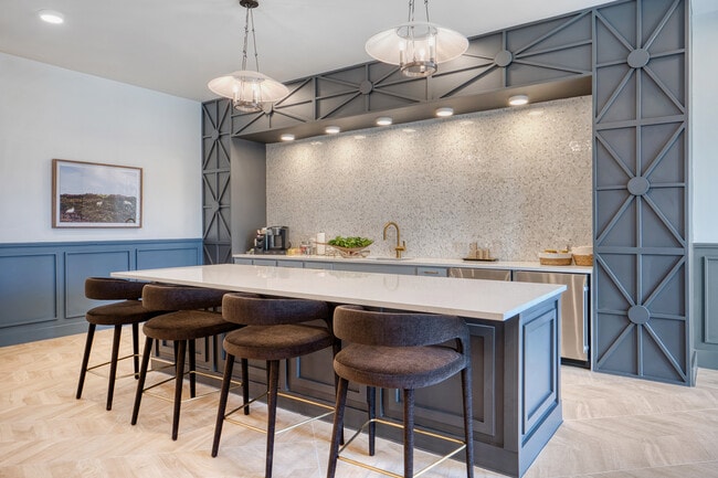 Stylish community bar with blue cabinetry and pendant lighting at Mesquite Trails at Brooks
