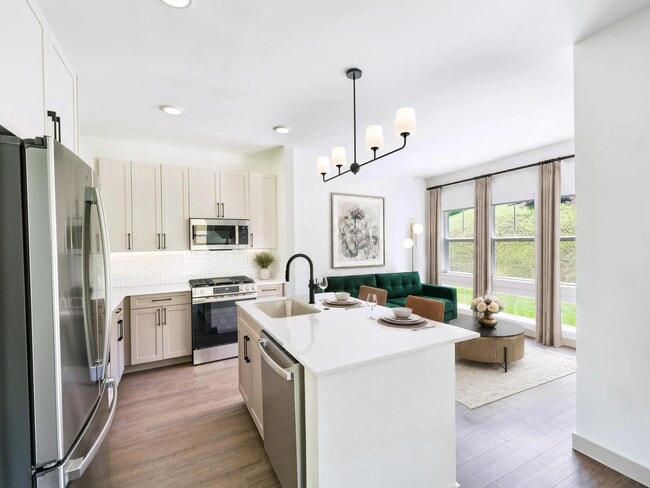 Open kitchen with a generous island, quartz surfaces, and oversized windows that bring natural light into the heart of the home. - Modera Weston