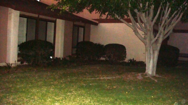 Vista nocturna de la zona de la puerta principal (la vivienda está al final del pasillo; solo comparte una pared). - 2870 N Cottonwood St Unidad 14