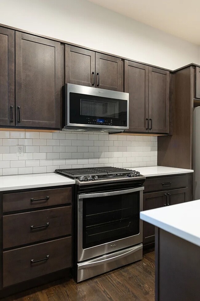 Cocina completa con electrodomésticos de acero inoxidable, que incluyen microondas, cocina a gas, lavavajillas y refrigerador. - 3505 S Marion St