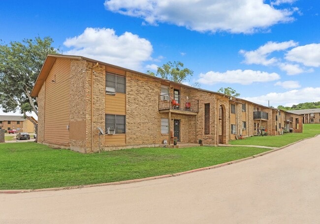 Apartment exterior with brick design and convenient resident parking. - Sierra Nevada