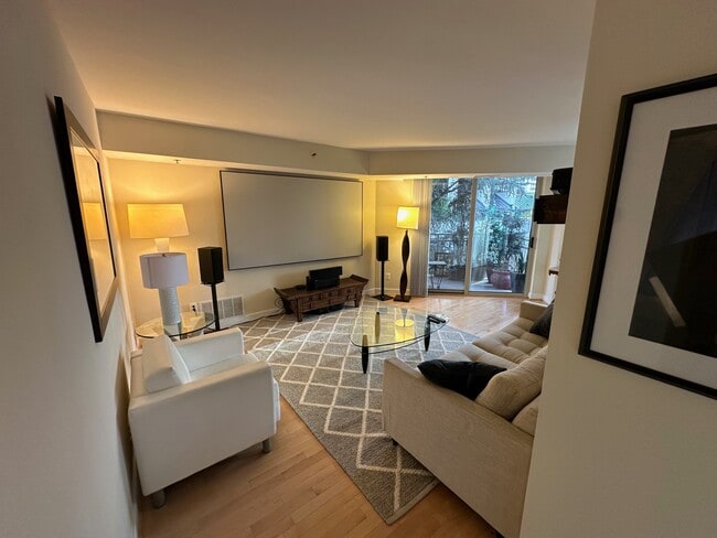 Living room with HD projector and 100" screen and hi-end sound system - 7500 Woodmont Ave Unit 407 Rental