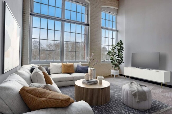 Living Room With Expansive Windows - Residences at Slatersville Mill Apartments