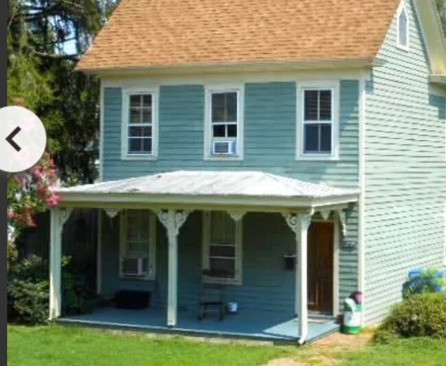 Front of house with covered front porch. Apartment is lower level. - 12775 Main St Apartments