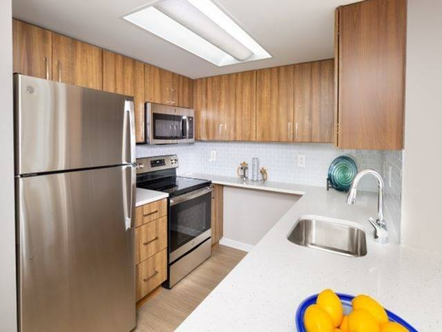 Newly Renovated Kitchen with Quartz Counter Tops, Stainless Steel Appliances and Wood-Style Flooring
