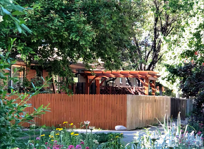 View of the fenced-in yard and pergola from the front - 2220 Irving St Rental