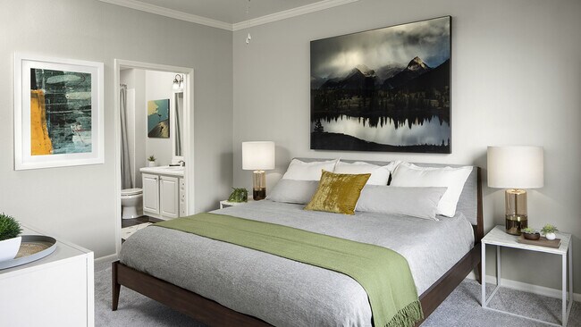 Spacious apartment bedroom with carpeted floors overlooking bathroom. - Sagebrook