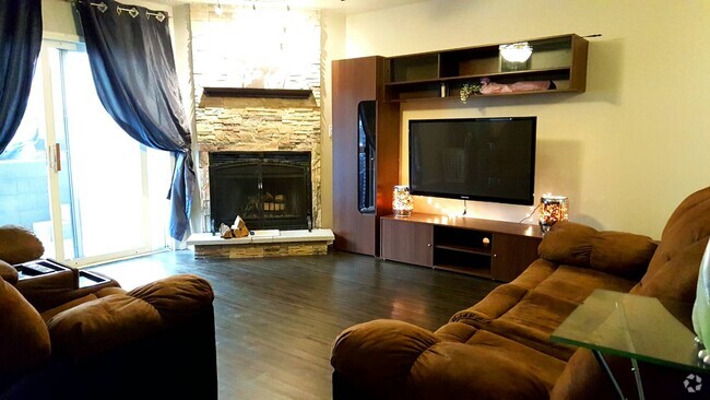 Living room with floating flat screen TV and fireplace with stone facade - 1920 Tracy Drive Unit 7 Rental