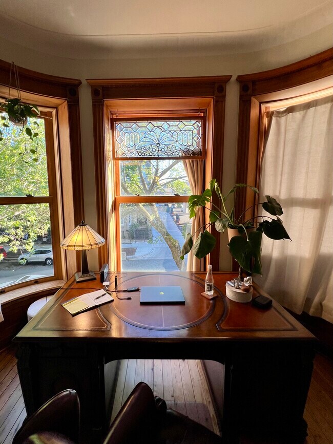 Beautiful mahogany antique desk in front bay window - 938 W Newport Ave