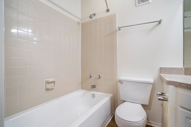 Renovated Package II bath with laminate countertops, white cabinetry, and hard surface flooring