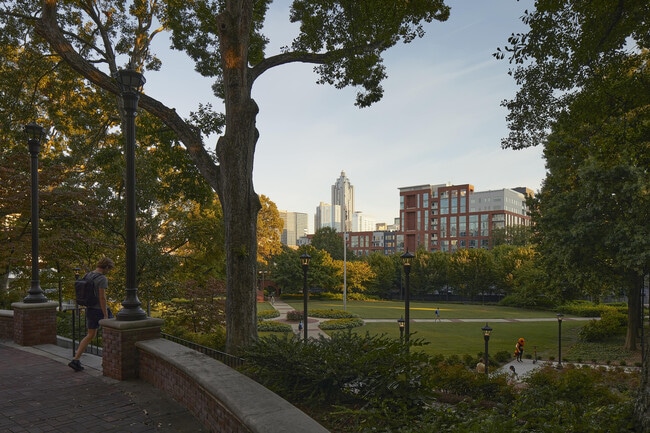 Experience the tranquility of urban living with this view of a serene park set against a modern skyline.
