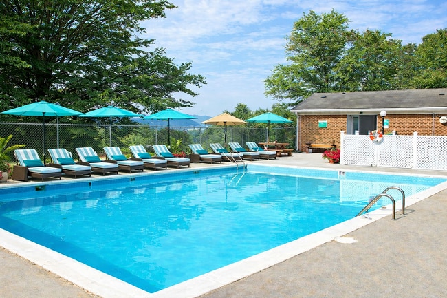 Sunny poolside retreat with umbrellas - Mountain Ridge Apartments