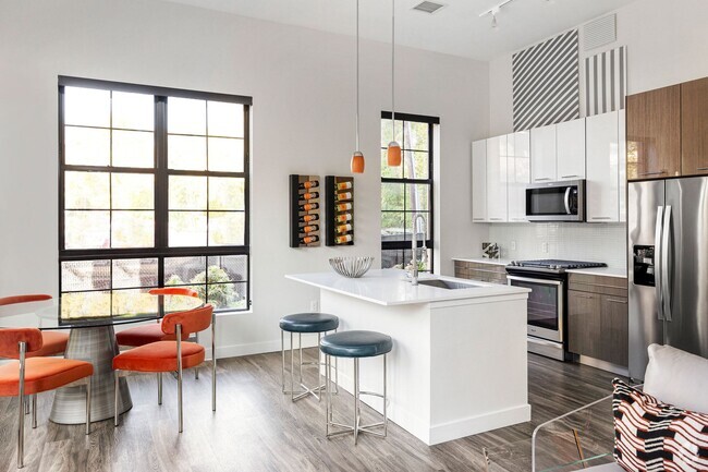 The chef-inspired kitchens feature gas stoves, stainless steel appliances and quartz countertops - Edison on the Charles by Windsor Rental