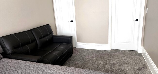 "Bedroom storage with modern loveseat & crisp neutral tones - 822 E 4th St Unit #1