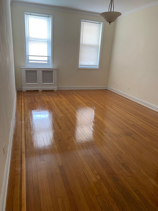 Living room with redone hardwood floors and custom radiator cover - 286 Corbin Plz Unit 2C