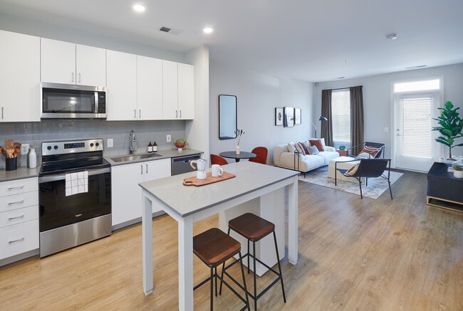 Design Collection II kitchen, living, and dining areas with hard surface flooring throughout - Avalon Foundry Row