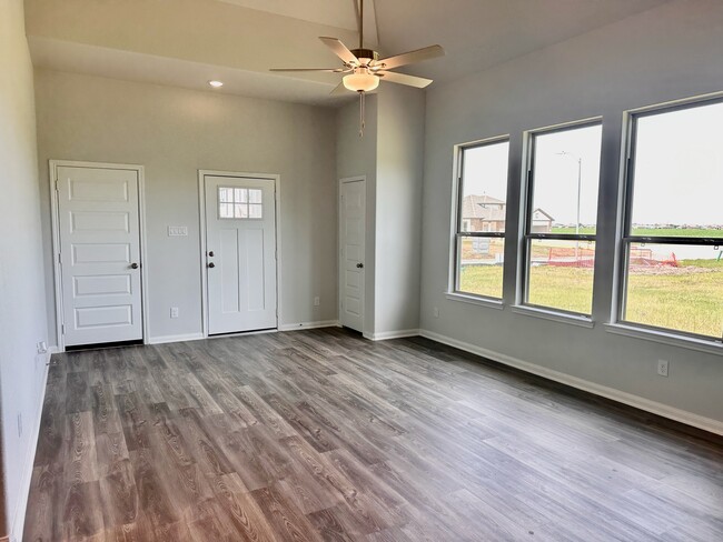 The modern flooring and ceiling fan immediately elevate this space!