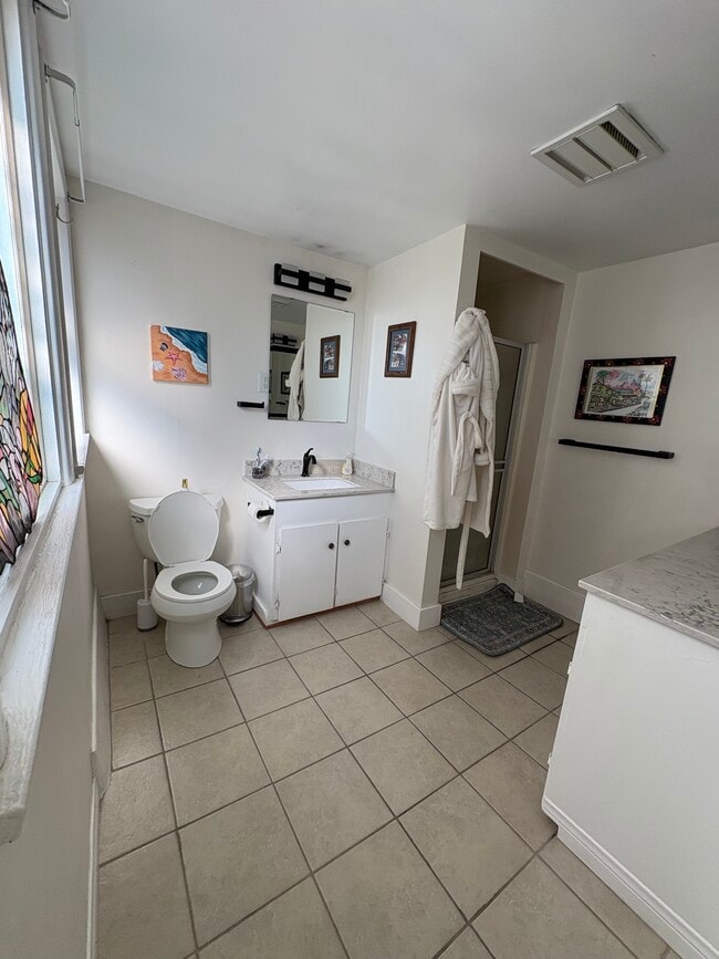 Spaciously updated bathroom with quartz countertops and storage. - 125 26th St