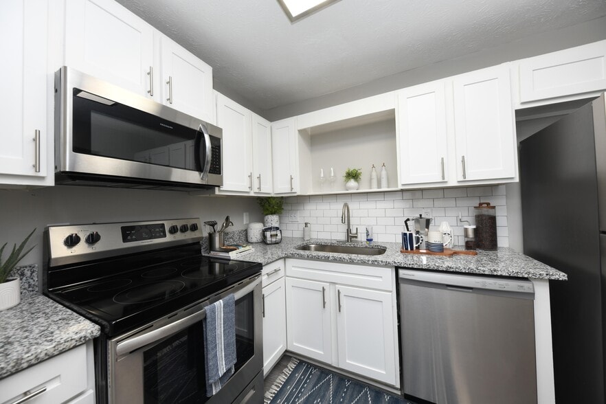 Kitchen with granite counters, modern cabinetry, and stainless appliances
