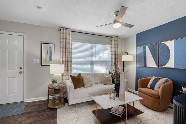 Spacious living room with hardwood-style flooring & ceiling fan