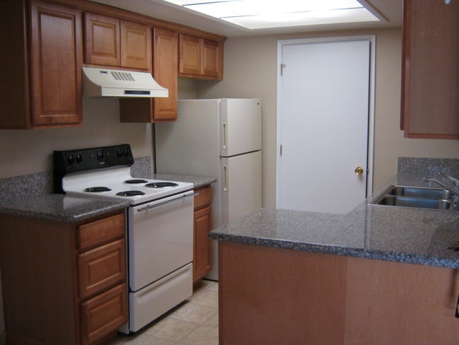Kitchen with Granite Counters and Oak Cabinets - Cascade Park Apartments