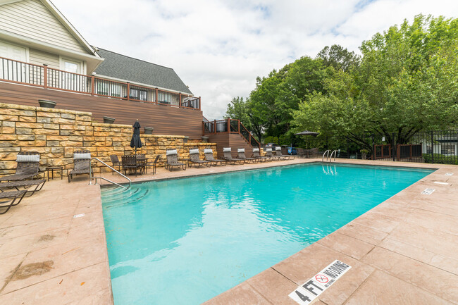 Sparkling pool with poolside lounge furniture and umbrellas - Decatur Flats Apartments