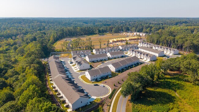 Community aerial showcasing homes, streets, and green spaces from above. - Carlton Crossing