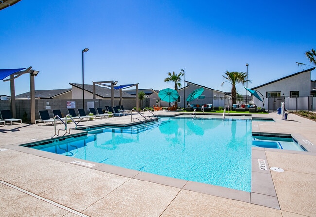Relax by the poolside in a serene, sun-filled environment perfect for leisure and comfort.
