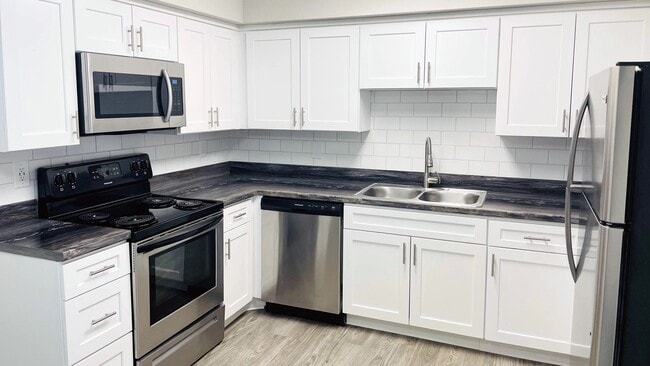 Experience kitchens with shining stainless-steel appliances and glimmering white subway tile backsplash - for a touch of modern elegance in all floor plans. - Slate Luxury Apartments