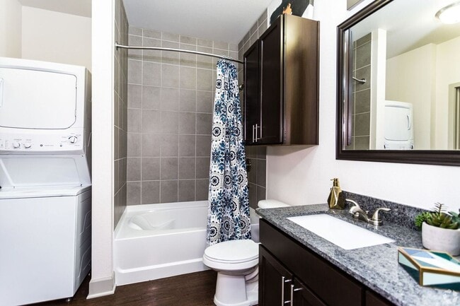 Classic Package bath with espresso cabinetry, speckled granite countertops, and hard surface flooring