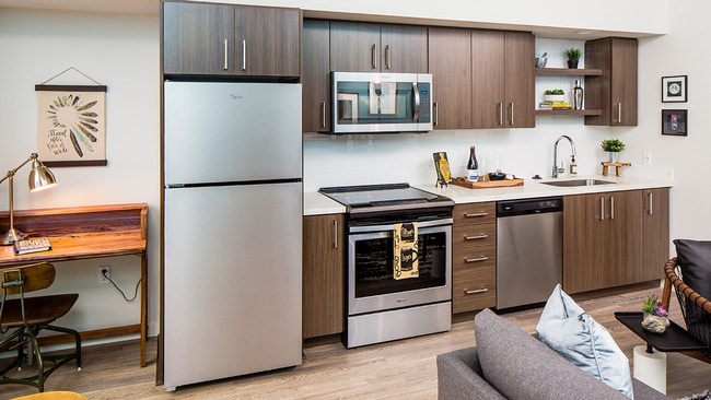 Contemporary kitchen design featuring stainless steel finishes and open shelving.