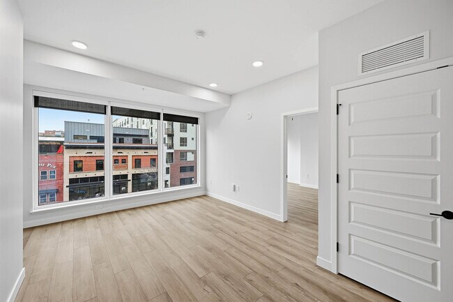 Large bedroom with large windows featuring city views - AMLI Golden Triangle