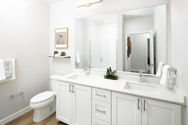 Finish Package I bath with white cabinetry, white quartz countertop, and hard surface flooring