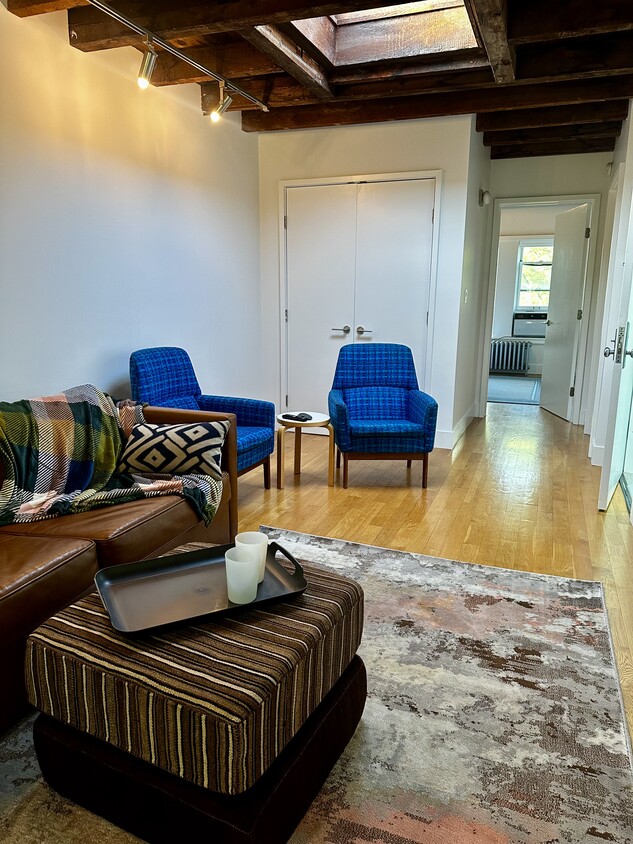 Living Room: fold-out sleeper couch, Samsumg smart TV, skylight, exposed beams - 682 President St (Brooklyn, NY)
