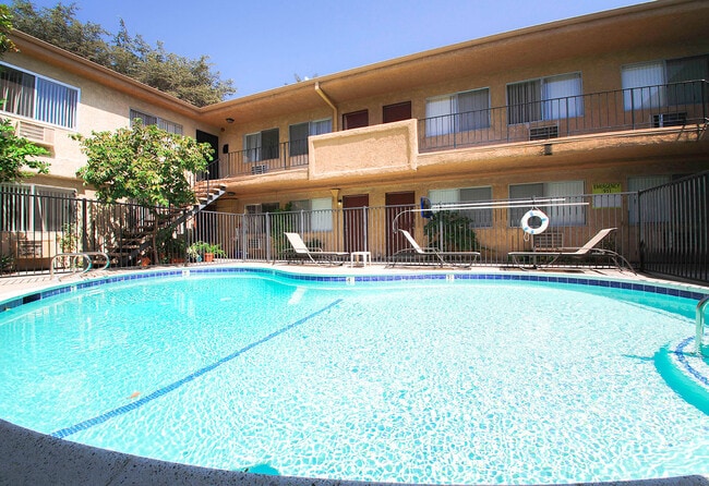 View of gated community pool with lounging space.
