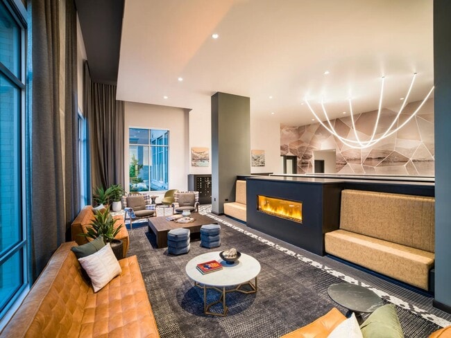 Warm tones and modern finishes create an inviting lounge at Modera Shoreline—perfect for connecting with neighbors or relaxing fireside.