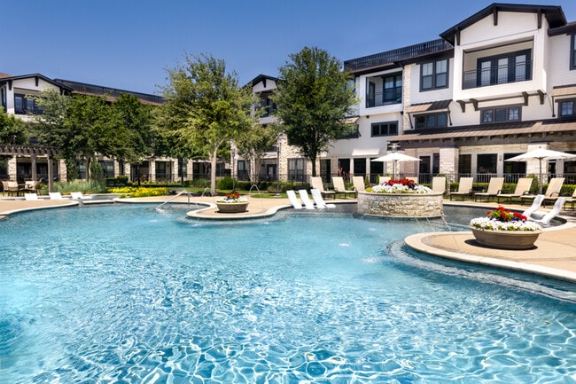 Pool includes expansive tanning area and water feature - StoneLedge Apartments