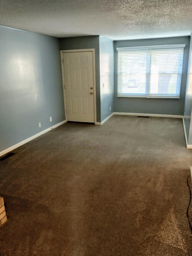 Other half of the living room with new window treatments - 2024 64th St Townhome