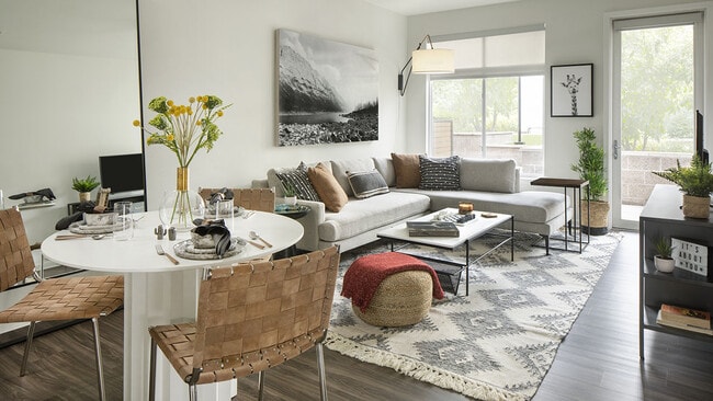 Apartment dining and living room with wood-style flooring.