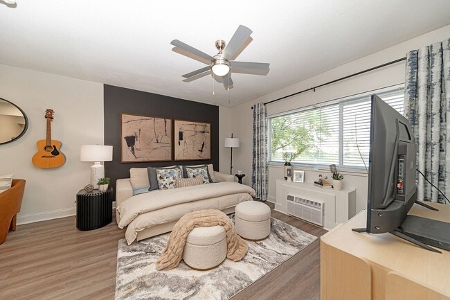 Spacious open living & sleeping area with hardwood-style flooring & ceiling fan