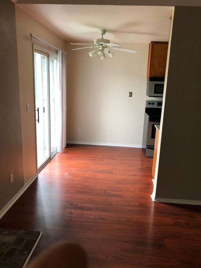 from the family room, looking into the kitchen with ceiling fan/light fixture, balcony and sliding door - 445 Almond Dr. #29 Unit Cambridge Place