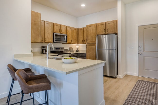 Spacious kitchen peninsula with convenient bar seating at Sageland Flats at Brooks