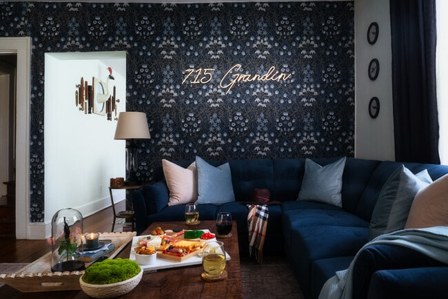 A stylish seating area with plush cushions, warm lighting, and a sleek “715 Grandin” sign - 715 Grandin Rd