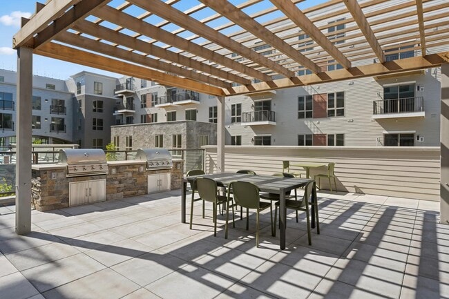 Patio exterior con zona de parrilla y comedor. - Modera Newton